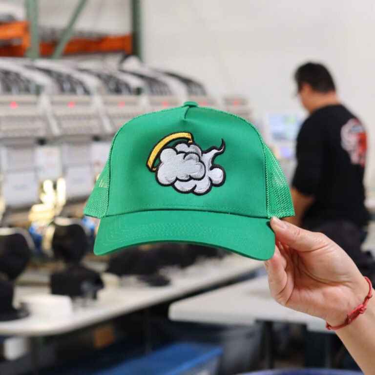 Front view of a custom embroidered green OttoCap 32-285 Kelly trucker hat with bold logo design on the front panel.