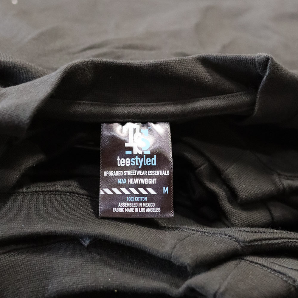 Neck woven label on Custom Puff Screen Printed TeeStyled TS7000 Black T-shirt for The Saddest Faction Clothing Company.