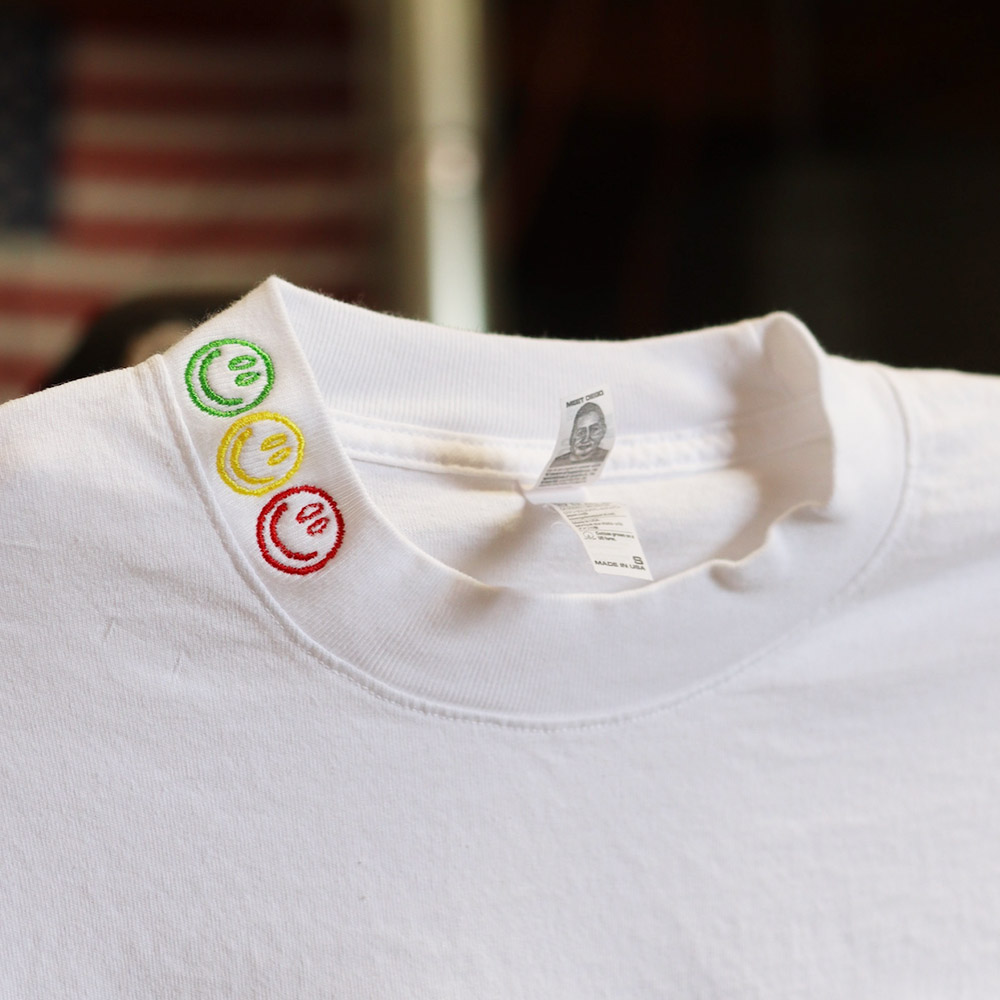 A white t-shirt with colorful laundry care symbols on the label.