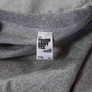 The neck label view of Los Angeles Apparel MT01 Mock Twist Crew Neck Tee in Yukon Army Grey Heather Black combines premium 8.0 oz fabric with a sleek and durable design. The neck label view showcases the branding details and product specifications. This label is attached by Garment Decor, perfect for creating standout branded apparel. With its high-quality construction and stylish look, this tee is ideal for teams, events, or casual wear.