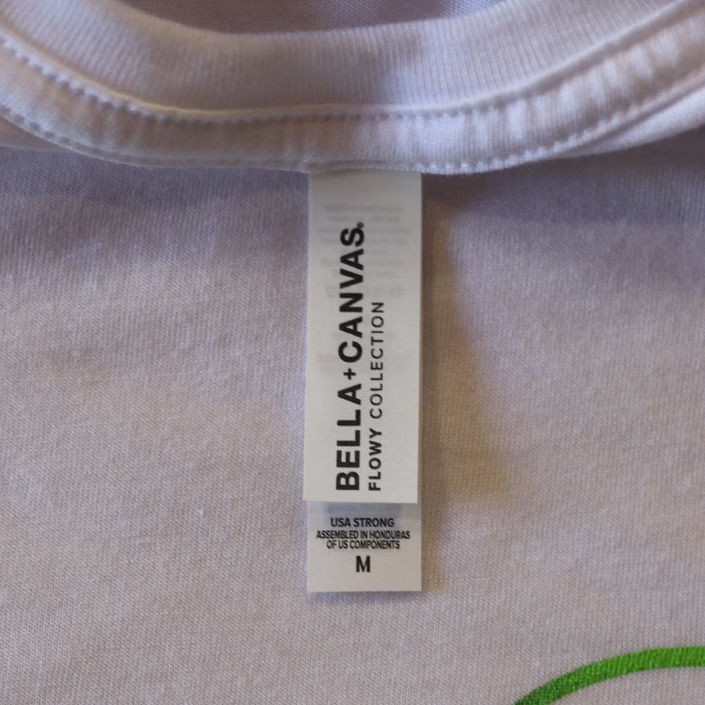 Detailed shot of the printed neck tag on the Bella + Canvas 8882 Women’s Flowy Crop Tee in white. Custom branding by Garment Decor adds a professional, retail-ready finish to this trendy crop tee.