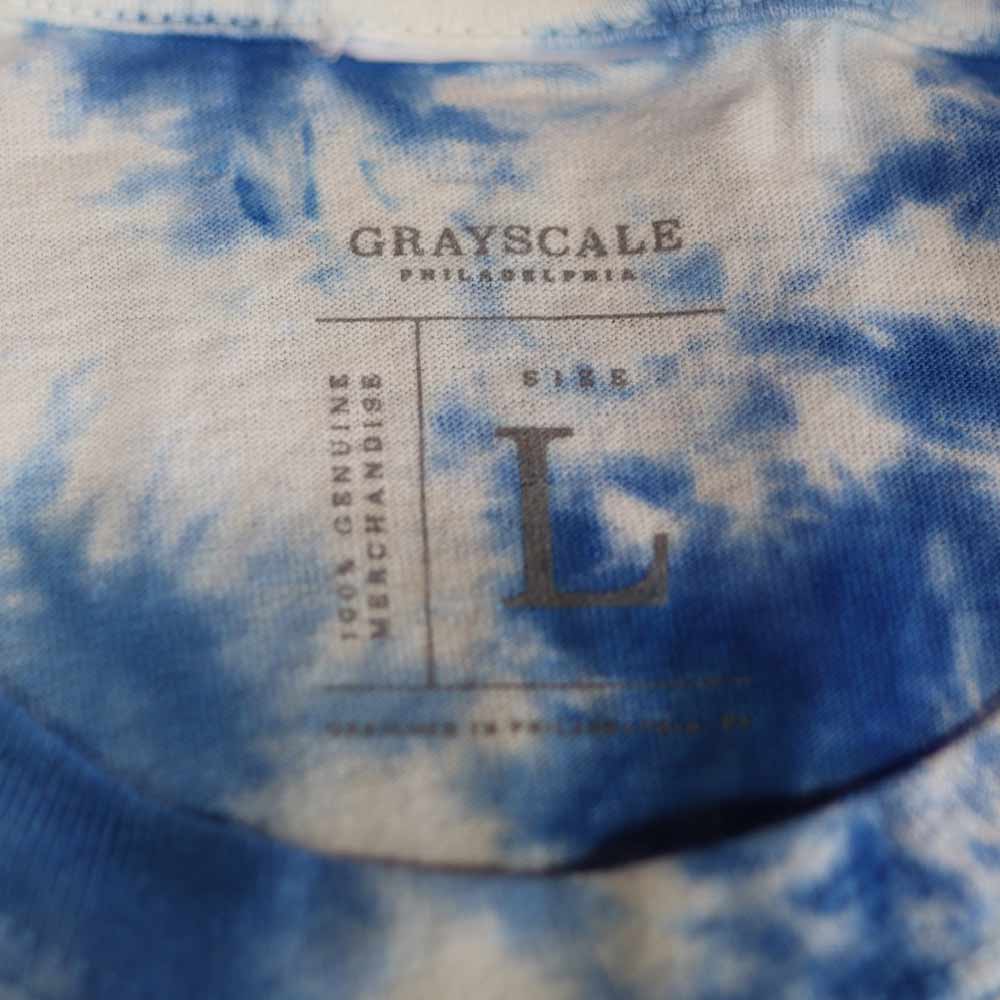 Detailed view of the printed neck tag on the 1390 Crystal Wash Tie-Dye T-Shirt in Carolina Blue. The seamless tag design, paired with Garment Decor's custom screen printing expertise, ensures a premium, tagless comfort experience.