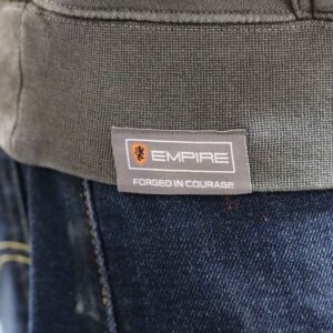 A close-up image focuses on the woven label detail sewn onto the hem of the Independent Trading Co. PRM4500 Hoodie. The label subtly showcases the "Empire Bikes" branding, underscoring attention to detail and Garment Decor’s expertise in customization. This thoughtful addition elevates the hoodie, blending comfort, design, and branding seamlessly.