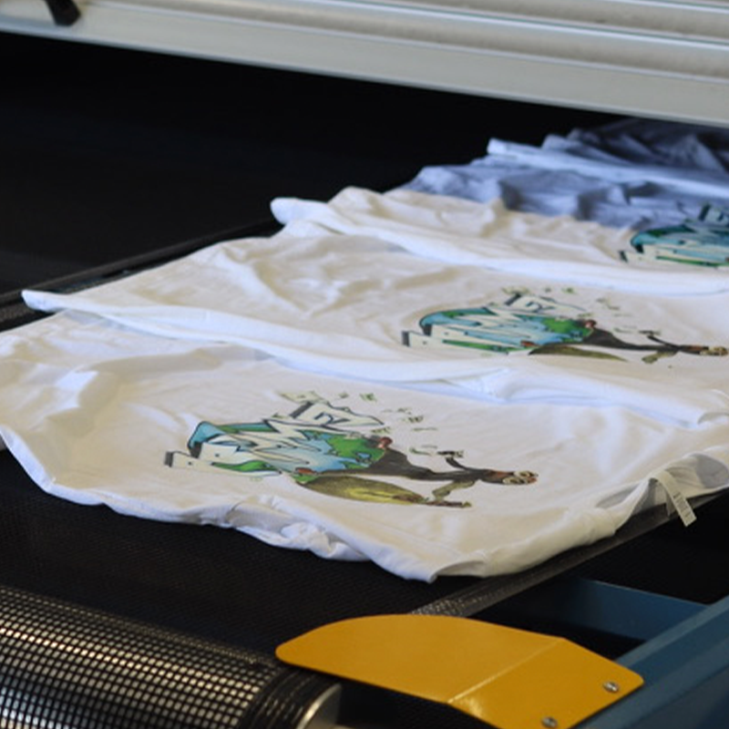 This is a photo of Bella + Canvas style 3001 t-shirts on our conveyer belt after they were printed with our digital squeegee.