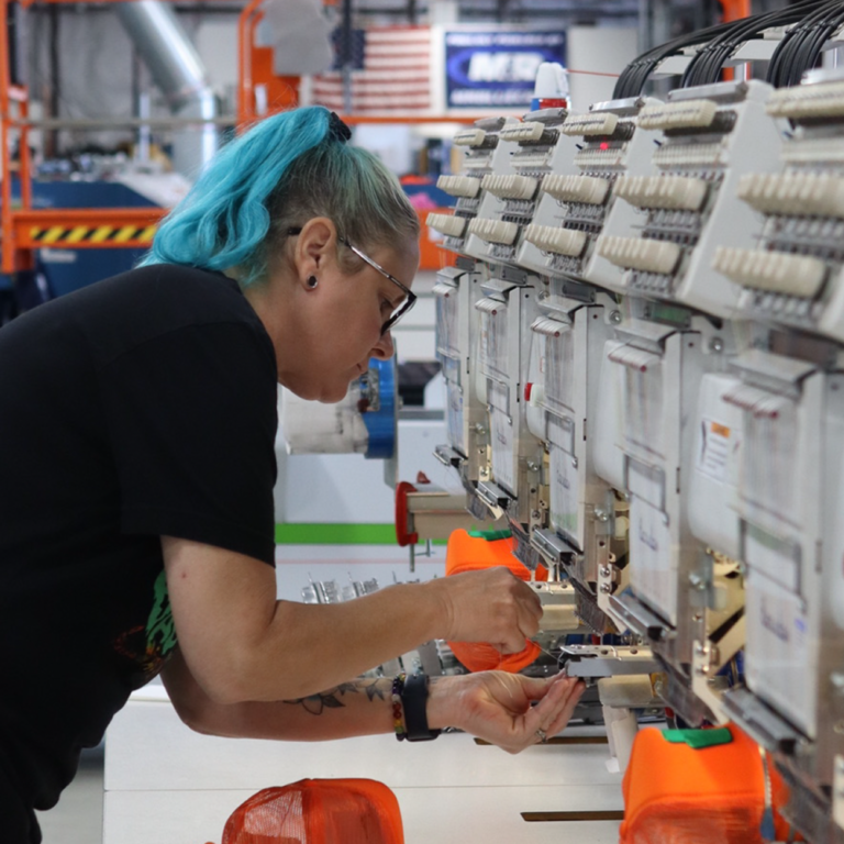 This photo shows our operator on the embroidery machine to display what a Garment Decor screen printing and embroidery career may appear like