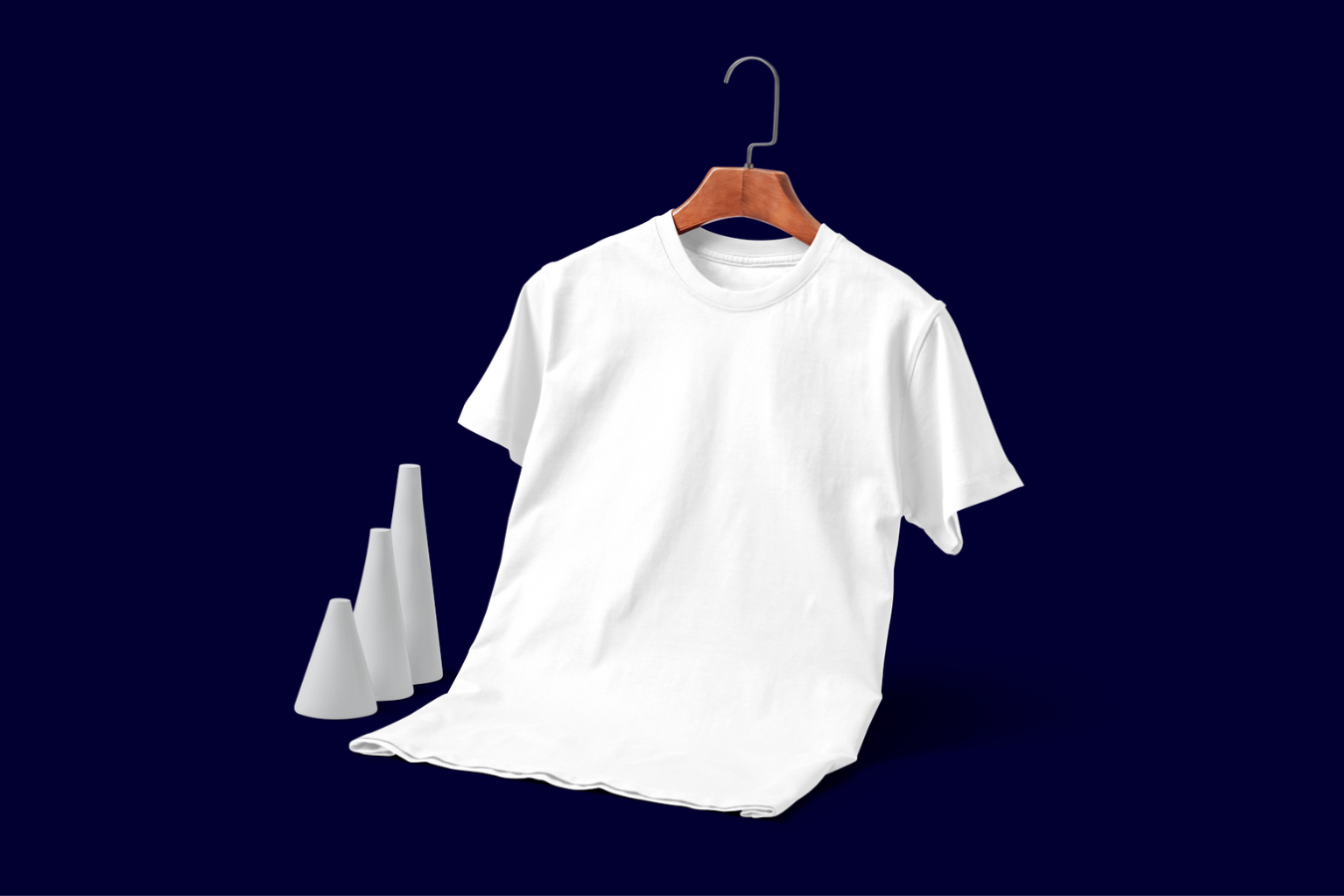 Plain white t-shirt on a hanger against a navy blue background, flanked by abstract white shapes.