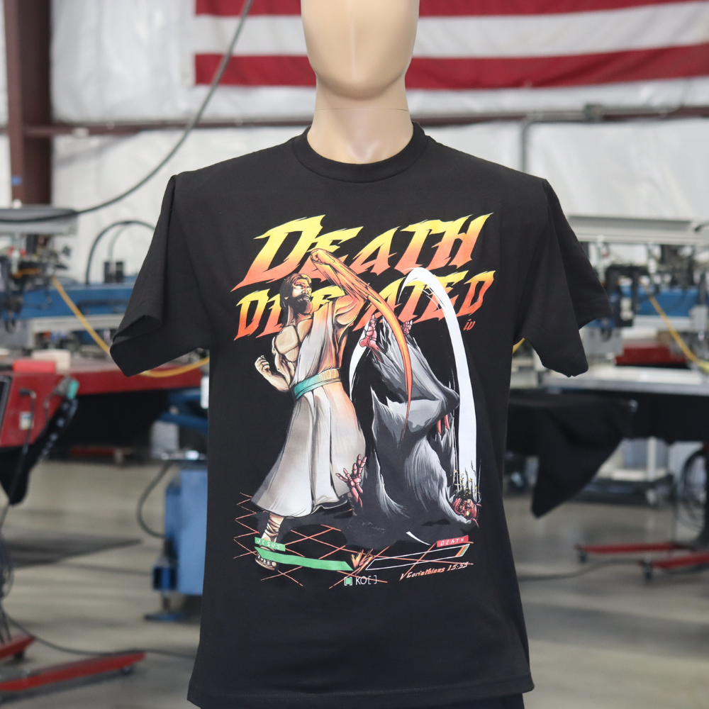 A black t-shirt with a "death dealer" graphic print on a mannequin in an industrial setting.