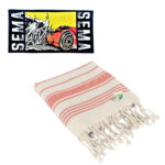 A sema flag above a folded striped towel with tassels.