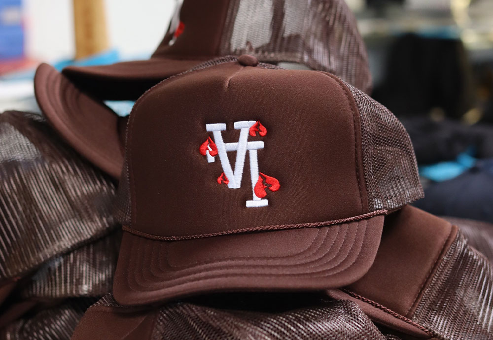Brown caps with white and red embroidered logo on display.