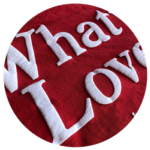 Red circular fabric for brands with the words "what is love" embroidered in white.