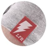 Close-up of a gray fabric with a red and white lightning bolt tag indicating "lfr" for brands.