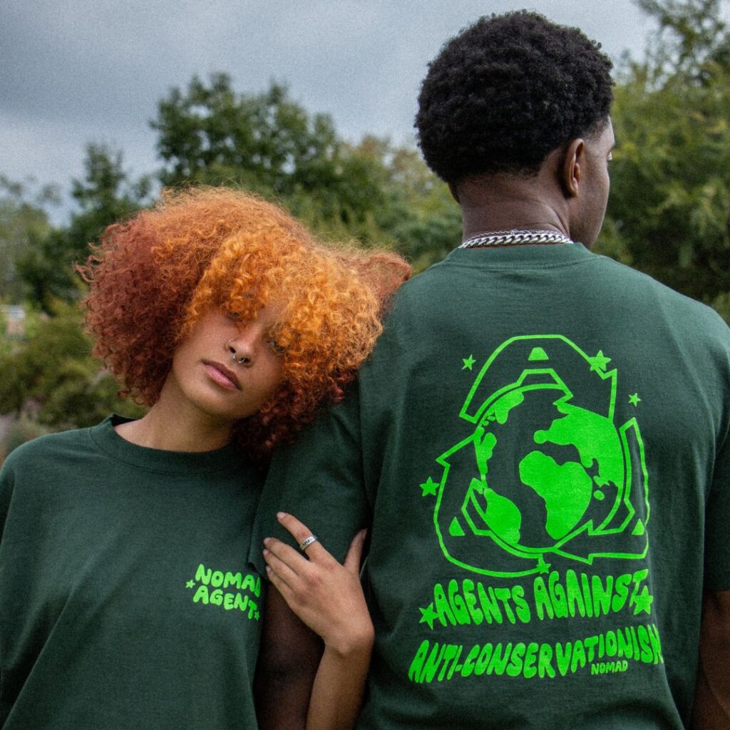 Two individuals wearing Custom Printed Heavyweight Cotton T Shirts with environmental advocacy slogans, posing back-to-back.
