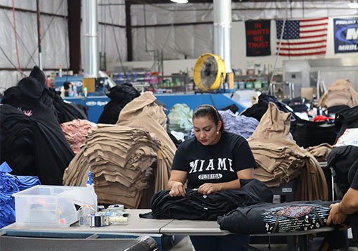 A woman working at a garment inspection station in a clothing factory.