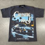 A black t-shirt with a graphic of a porsche car and palm trees, featuring the text "chasing 10's" and "excellence over epochs".
