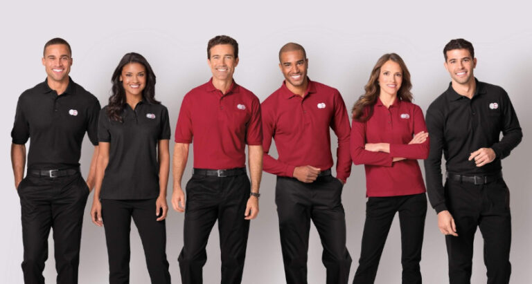 Five people standing in a row, showcasing wholesale custom apparel, with the men in black pants and long-sleeved shirts and the women in black pants and short-sleeved shirts.