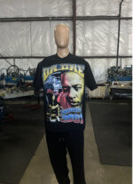 A mannequin in a warehouse wears a 100 Jumbo Oversized T Shirt Printing - Garment-Dyed Heavyweight Shirts with Screen Printing (17" W x 23" H) - Ideal for Oversized T-Shirt Designs - Rap Style - Premium featuring images and text related to a music album. Industrial equipment is visible in the background.
