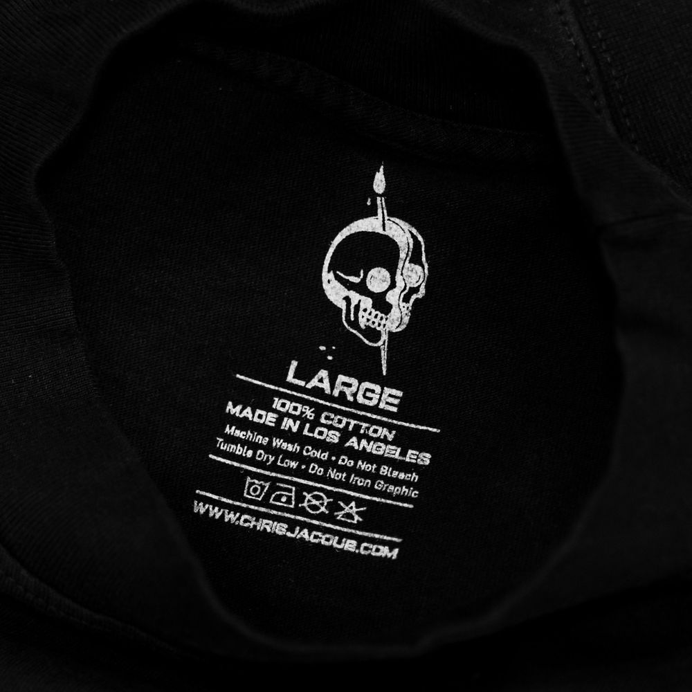 Custom screen printed neck tag on a 100% cotton t-shirt that shows the clothing brand's information in gray ink. - Garment Decor Custom jumbo screen printed neck tag on Bold Skull and Wilting Rose Design: Los Angeles Apparel 1801GD 6.5oz Garment Dye Crew Neck T-Shirt Black that shows the clothing brand's information in gray ink.