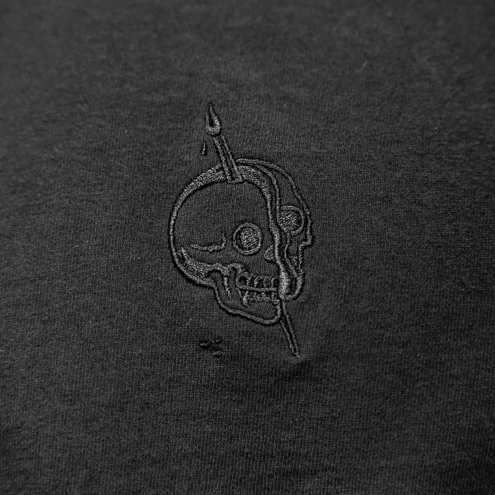 Custom embroidered tonal design in black thread on a Los Angeles Apparel 1801GD 6.5oz Garment Dye Crew Neck T-Shirt front view - Garment Decor Custom embroidered tonal design in black thread on a Los Angeles Apparel 1801GD 6.5oz Garment Dye Crew Neck T-Shirt front view