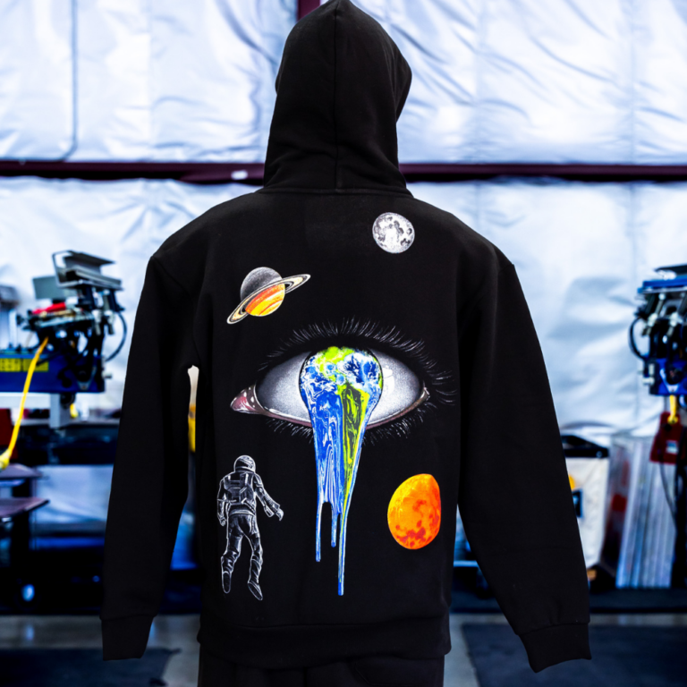 The mannequin wearing the back view of a black Independent Trading Co. IND420XD MAINSTREET 420GM HEAVYWEIGHT PULLOVER HOOD with jumbo screen print design for Jacoub printed by Garment Decor. - Garment Decor The mannequin wearing the back view of a black Independent Trading Co. IND420XD MAINSTREET 420GM HEAVYWEIGHT PULLOVER HOOD with jumbo screen print design for Jacoub printed by Garment Decor.