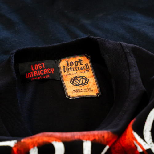 This is the neck label view of custom jumbo screen printed black Los Angeles Apparel 1801GD 6.5oz Garment Dye Crew Neck T-Shirt with edgy Lost Intricacy design printed by Garment Decor.