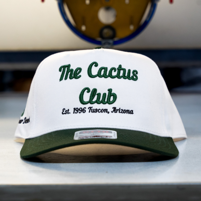 Otto Cap 31-069 5 Panel Mid Profile Baseball Cap Dark Green White Custom 3D Puff Embroidery Front View - Garment Decor The front view of the dark green / white OTTO CAP 31-069 5 Panel Mid Profile Baseball Cap highlights a custom 3D Puff embroidery design of The Cactus Club embroidered by Garment Decor, demonstrating premium craftsmanship ideal for streetwear brands aiming for a bold and professional look.
